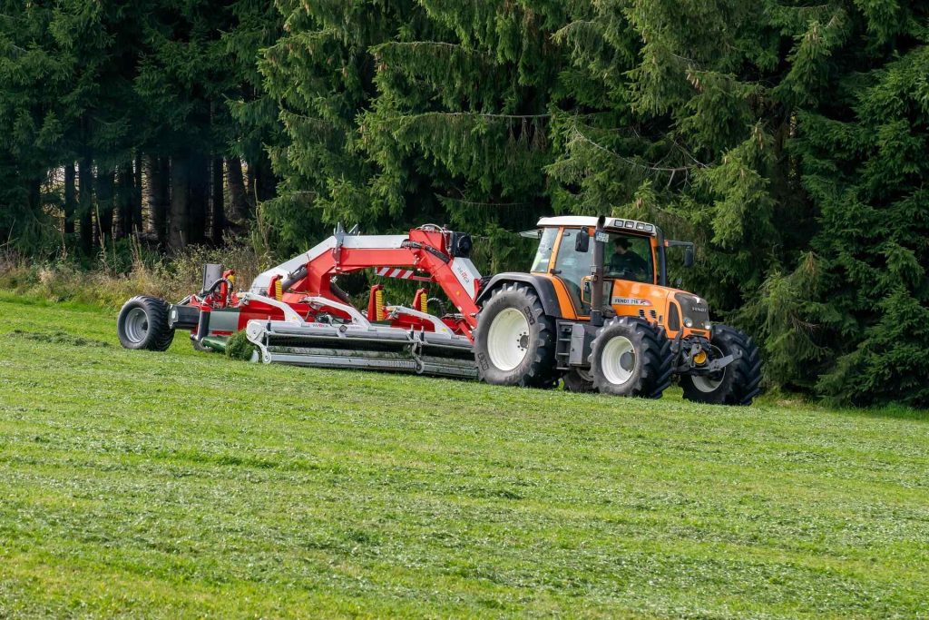 Tractor mowing grass in field